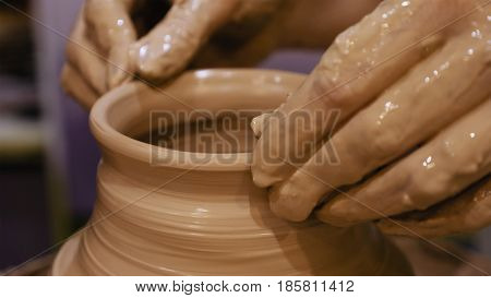 Potter is making clay pot bowl or vase ceramics porcelain on the potter's wheel. Creating pottery art and handicraft modelling creation.