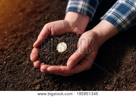 Making income from agricultural activity and earning extra money female farmer handful of soil with euro coin
