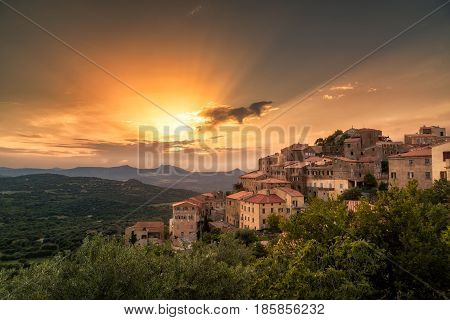 Ancient hilltop village of Belgodere in the Balagne region of Corsica lit up by a dramatic evening sunset