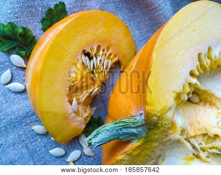 Pieces of cut pumpkin with seeds on the table.