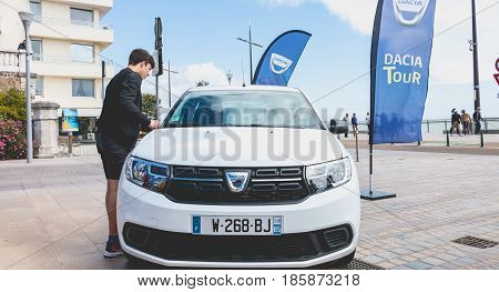 Sables d Olonne France - May 07 2017 : Dacia Tour 2017 is a commercial operation organized by the car builder in order to present its cars throughout France - A young man watching a car