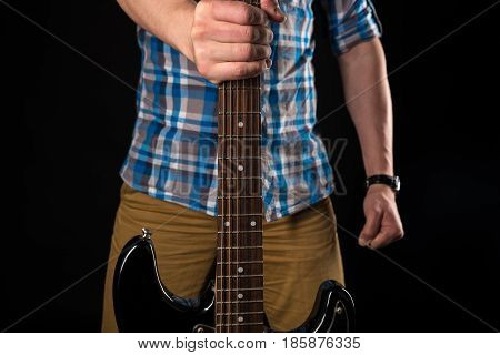 Music And Art. The Guitarist Holds An Electric Guitar In His Right Hand, On A Black Isolated Backgro
