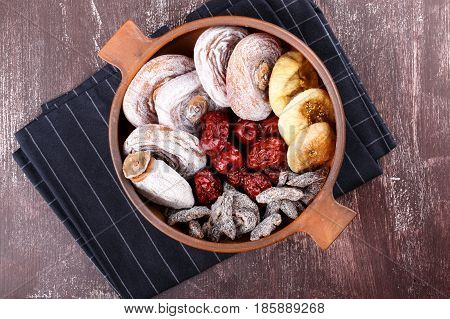 Dried fruits - persimmon figs red dates or jujube and salted sliced plum. Top view.