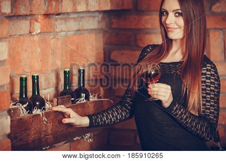 Woman Tasting Wine In Rural Cottage Interior