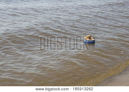 Toy ship floats in water. Returned to the shore