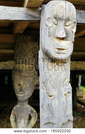 The culture and beliefs of the island Borneo. Traditional Dayak tribal culture. Totem in front of Dayak house - long house. Kalimantan Indonesia