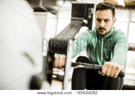 Young Man Doing Exercise For Triceps In The Gym On Mashine