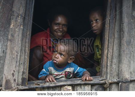 Wamena West Papaua Jayapura - February 13th 2016: Dani tribe boy with his family in his home