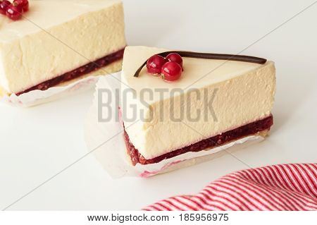 Mascarpone cheesecake with red currant and chocolate strip serving slices. Delicious dessert with berries.