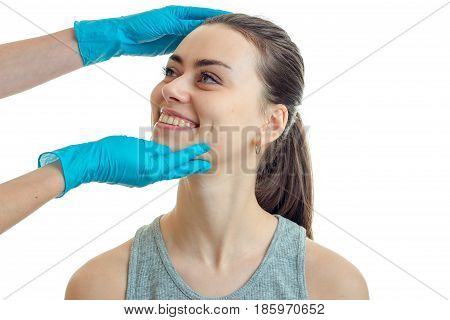 beautiful girl smiling at doctor-cosmetologist with blue mittens isolated on a white background close-up