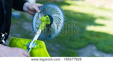 Man worker cutting grass with lawn mower.