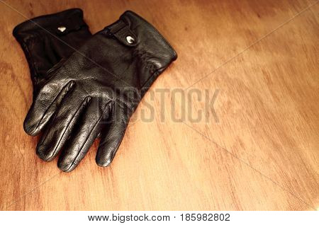 Pair of leather gloves on wooden board