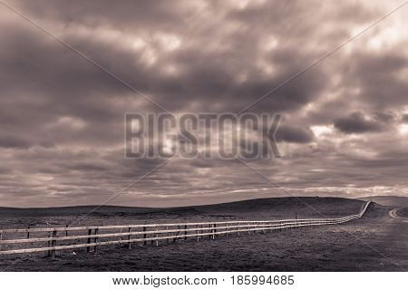 Long neverending wooden fence in the irish countryside, Ireland