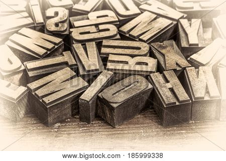 random vintage letterpress printing blocks on a grunge rustic wood, retro opalotype toning