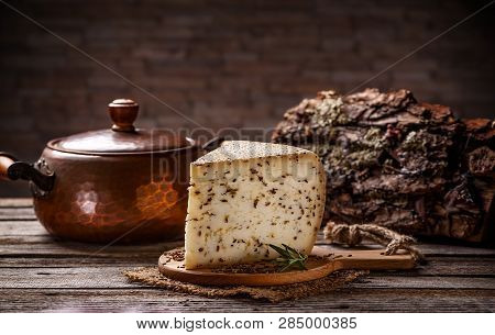 Wedge Of Cheese With Cummin On Vintage Wooden Background