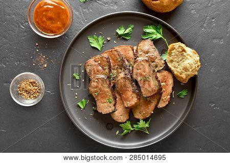 Beef Liver On Plate Over Black Stone Background. Sliced Grilled Liver(offal) From Beef Meat. Top Vie
