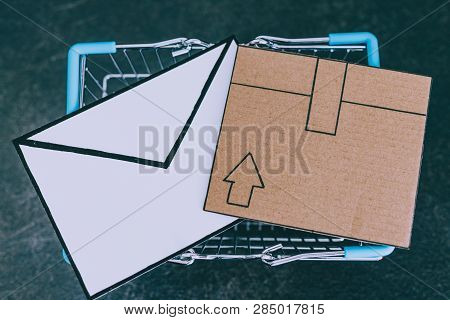 Shopping Cart With Cardboard Parcel And Email Envelope On Concrete Desk, Concept Of Shipping And Tra