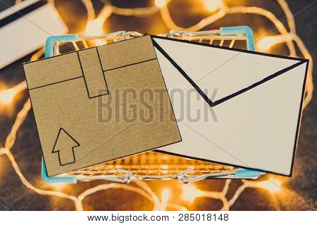 Shopping Cart With Cardboard Parcel Payment Card And Email Envelope On Concrete Desk Surrounded By F