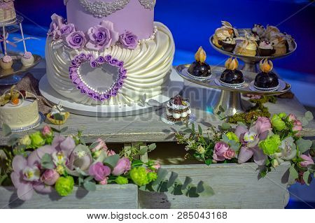 Wedding Cake And Specific Sweets Decorated With Artificial Flowers And Painted.