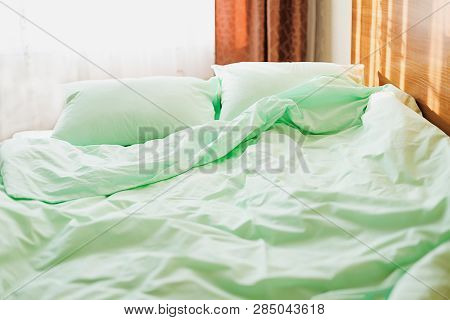 Minty Green Bedding On The Bed At The Early Sunny Morning. Wake-up Tipe.