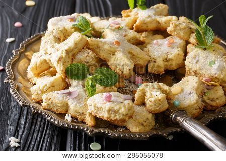 Christmas Figure Cookies With Pecans, Anise And Mint Decorated With Candy Sprinkles Close-up On A Di