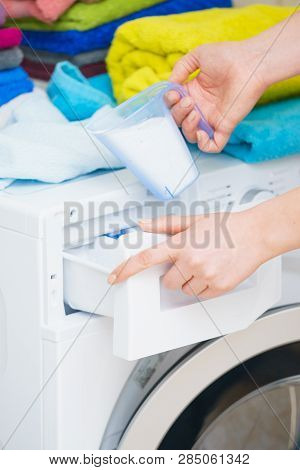 Washing Powder Detergent And Measuring Cup Pouring Into Machine. Household Duties, Clothes Laundry O