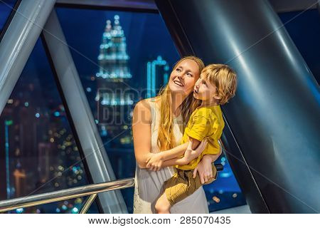 Mom And Son Are Looking At Kuala Lumpur Cityscape. Panoramic View Of Kuala Lumpur City Skyline Eveni