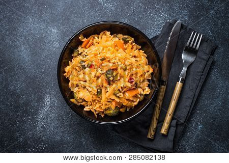 Cabbage Stew With Rice And Vegetables. Meatless Vegan Dish. Top View On Black Stone Table.