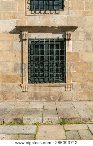 Trellised Railling On Window On Granite Stone Old Building Facade.