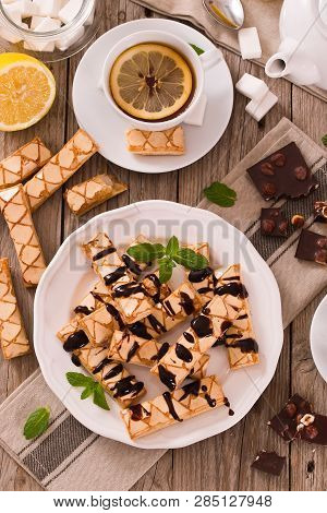 Puff Pastry Cookies With Chocolate Icing On White Dish.