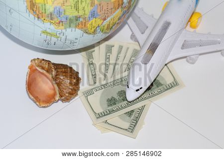 Planning A Trip Around The World. On Holiday With The Whole Family. In The Photo: Plane, Money, Shel