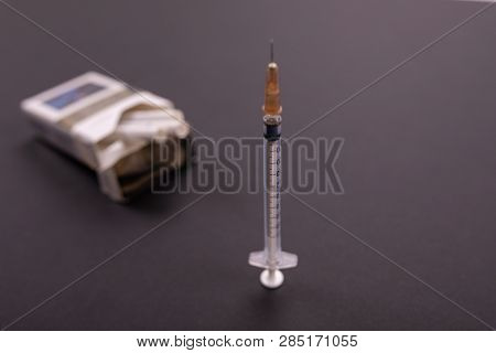 Syringes Stick Out Of A Pack Of Cigarettes