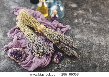 Bouquets Of Dry Lavender, Amethyst Druses And Lavender Oil In A Small Bottle On Dark Baclground. Alt