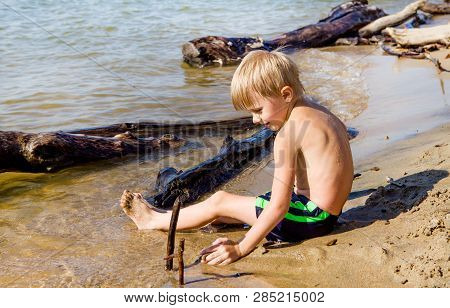 Child Playing In The Sand On The Summer Beach