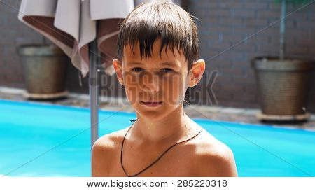 Wet Serious Boy After A Swimming Pool Looks At The Camera, Close-up