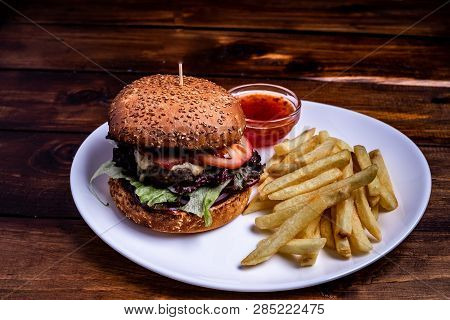 Beefburger With Fried Sweet Potatoes Served On A White Plate