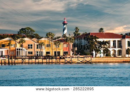 St. Augustine, Florida. January 26 , 2019. Old Lighthouse And Colorful Dockside On Cloudy Sky Backgr