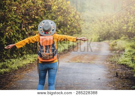 Asian Woman With A Shoulder Bag. She Raised Her Hands And Walked Down The Street Flower Garden Mexic