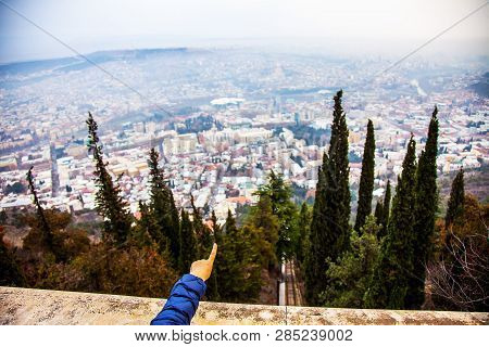 Hand Showing To Panoranic View From Mtatsminda Hill In Tbilisi, Georgia January 2019
