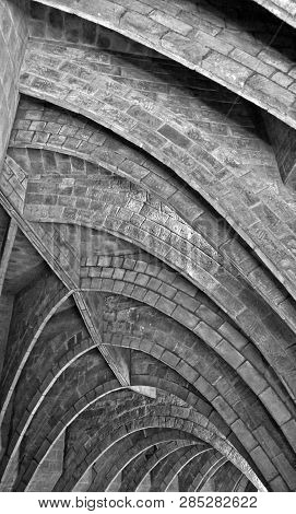 Monochrome Close Up Of Old Repeating Underground Pointed Brick Arches