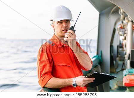 Deck Officer On Deck Of Offshore Vessel Holds Vhf Walkie-talkie Radio