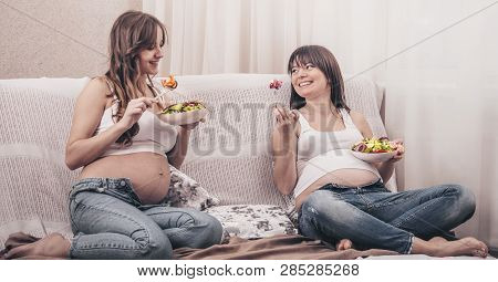 Maternity Concept, Two Pregnant Women Eating Fresh Salad At Home