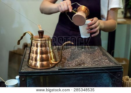 Process Of Making Coffee In Copper Jezva On Stones. Cooking Traditional Turkish Coffee In Pot, Selec