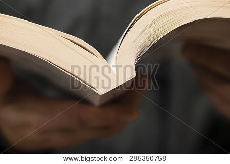 Detail Of Man Reading A Book With Dogears Bookmarks.
