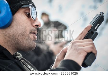 Close-up Detail View Of Shooter Hold Handgun In Row Group Of People On The Shooting Range