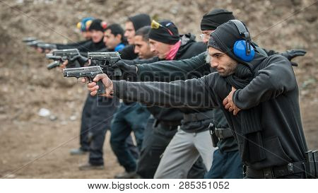 Close-up Detail View Of Shooter Hold Handgun In Row Group Of People On The Shooting Range