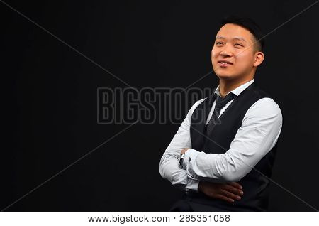 Young Asian Man Folded His Hands, Smiled, Looking Sideways