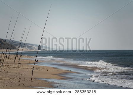 Many Fishing Rods In The Sand Beach