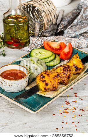 Skewers, Onions, Pita Bread, Sauce On A White Plate