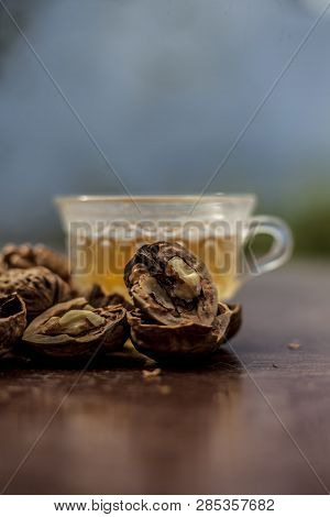 Close Up Of Herbal Organic Tea Of Wall Nut Or Walnut Tea In A Transparent Glass Cup With Raw Wall Nu